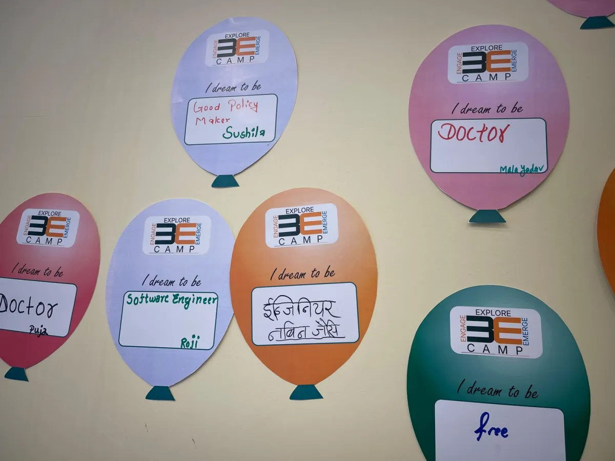 Paper balloons on a wall, each carrying a scholar's dream — "I dream to be" a good policy maker, a doctor, a software engineer, free