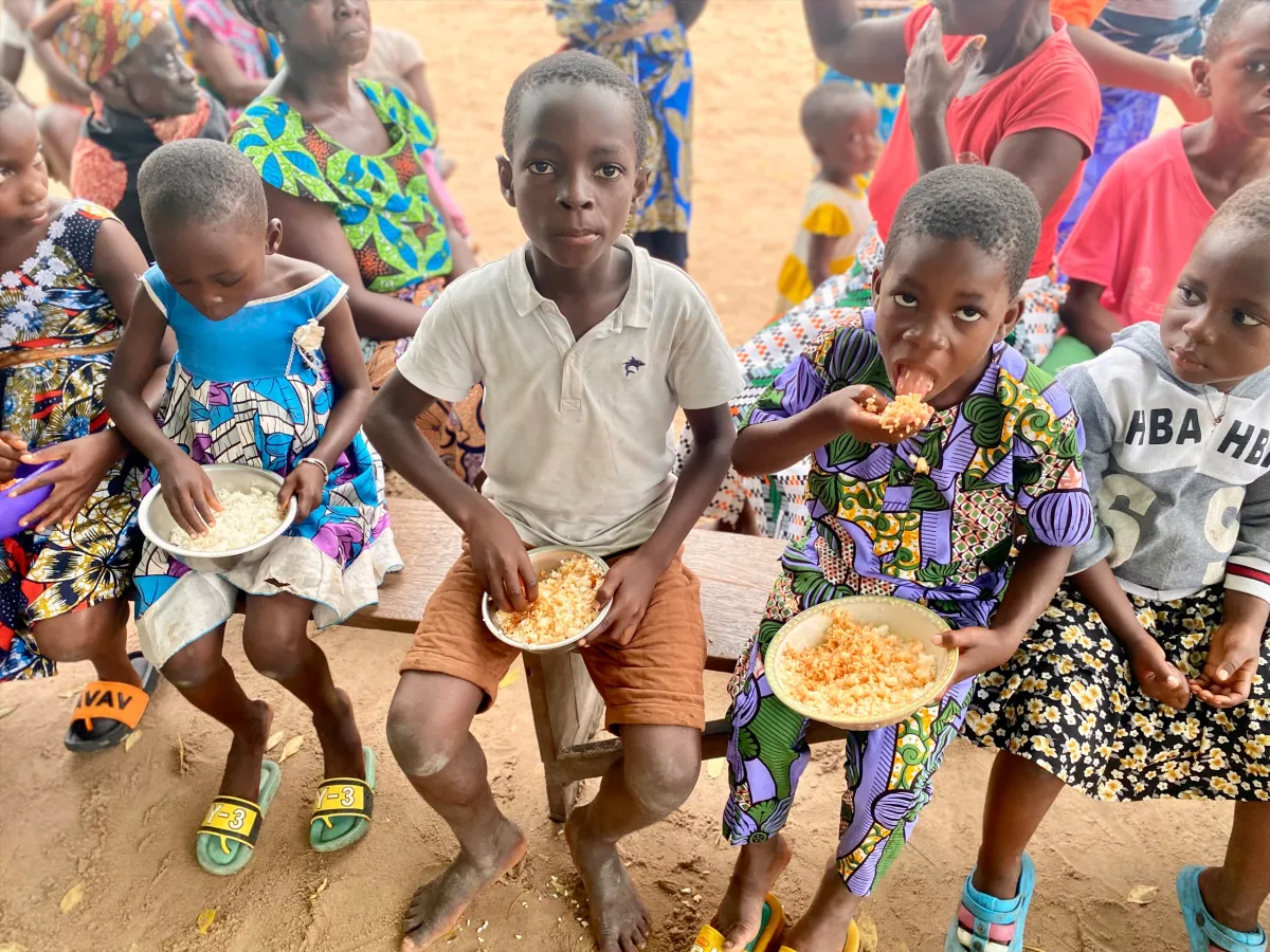 Children eating a meal together at the Happy Kids camp in Togo